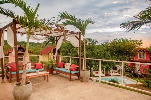 a patio with chairs and trees and a pool at Tiny Village Cartagena Boutique Resort in Tierra Bomba