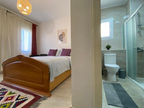 a bedroom with a bed and a shower and a toilet at Mountain View luxe chalet Ras elhikma families only in Ras Elhekma