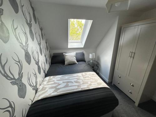 a small bedroom with a bed in the corner at Sleeps4-FamilyFriendly-FreeParking- Nc500 in Wick