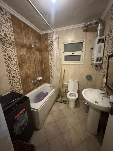 a bathroom with a tub and a toilet and a sink at الرحاب سيتي in New cairo