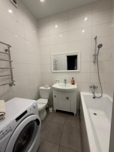 a white bathroom with a washing machine in it at Яровиця 167 in Lutsk