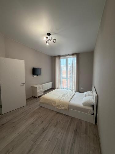 a bedroom with a bed and a large window at Яровиця 167 in Lutsk
