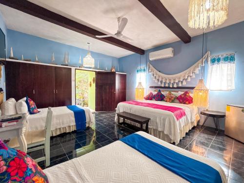 two beds in a room with blue walls at Casa Aluxes Hotel in Valladolid