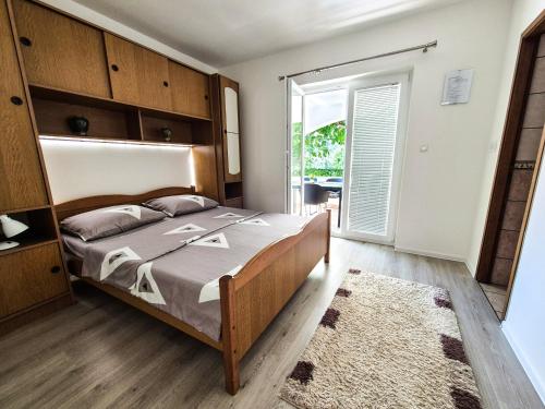 a bedroom with a large bed and a large window at Apartments Benkovic in Baška