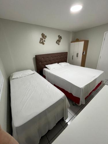a bedroom with two beds and a cabinet at Gran Lençóis Flat Residence Barreirinhas in Barreirinhas