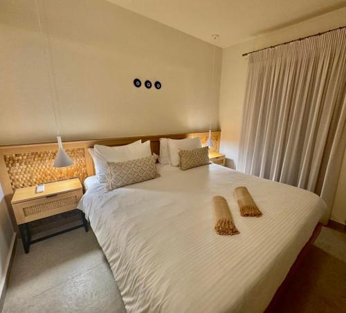 a bedroom with a large white bed with two baskets on it at House Marigo Suites in Koskinou