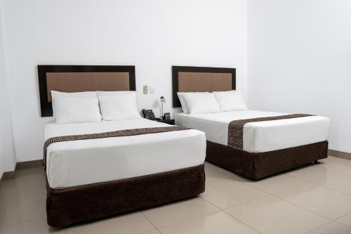 zwei Betten, die in einem Zimmer nebeneinander stehen in der Unterkunft Win & Win Hotel & Casino Piura in Piura