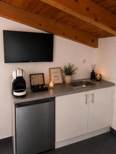 a kitchen with a sink and a tv on the wall at Ocean Breeze Luxury Loft in Psathopyrgos