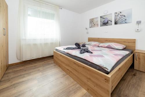 ein Schlafzimmer mit einem Holzbett, auf dem ein Teddybär liegt in der Unterkunft Bobnarica in Grahovo