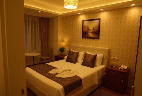 a hotel room with a bed with towels on it at Derya Hotel in Mersin