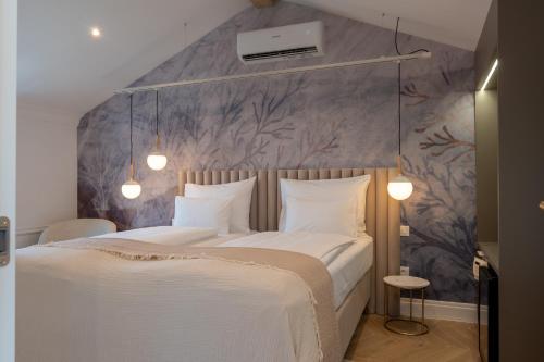 a bedroom with a white bed with a purple wall at Agava Design Residence in Split