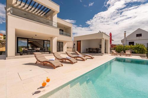 a villa with a swimming pool and lounge chairs at Villa Infinity in Rtina