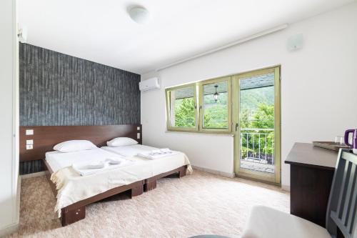 a bedroom with two beds and a window at Aparthotel HayatHills in Sarajevo