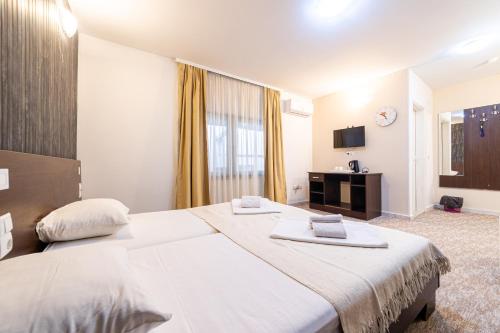 a hotel room with a large bed and a television at Aparthotel HayatHills in Sarajevo
