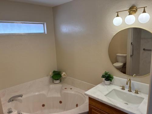 a bathroom with a tub and a sink and a mirror at Quail's Nest - Downtown Studio in Tucson