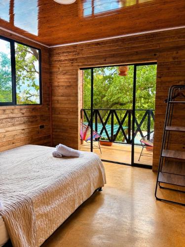a bedroom with a bed and a balcony with a ladder at Coffee House Minca in Minca