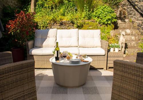 a table with a bottle of wine on a patio at An Glas Bras - By Rowes Retreats in Falmouth