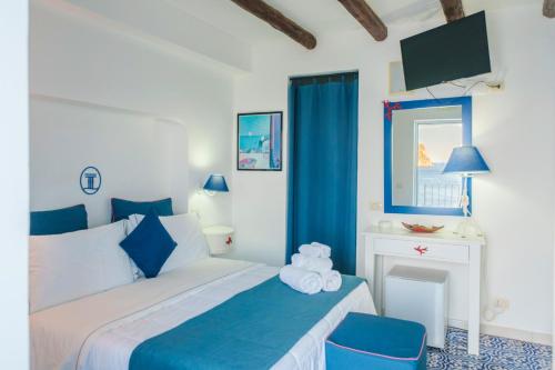 a bedroom with a bed with blue and white at Hotel La Terrazza in Panarea