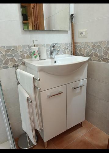 a bathroom with a white sink and a mirror at La casetta dei carciofi in San Fratello
