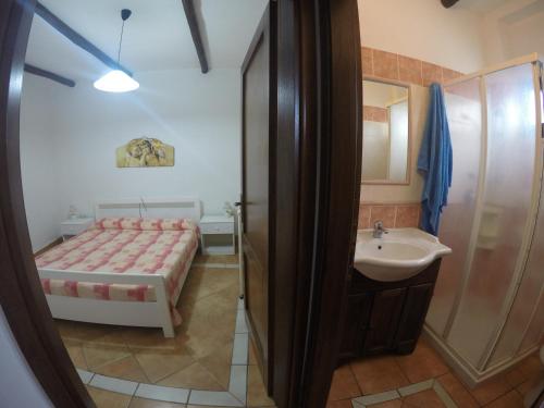 Baño pequeño con cama y lavabo en Appartamenti Con Vista Panoramica en Santa Maria Navarrese