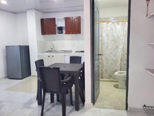 a kitchen with a table and chairs and a bathroom at Hostel HM Caribe in Santa Marta
