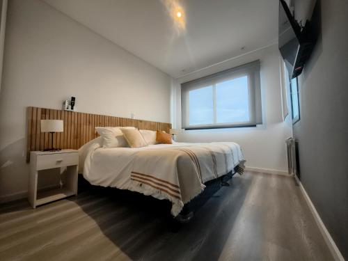 ein Schlafzimmer mit einem großen Bett und einem Fenster in der Unterkunft LEVEL Terrazas premium con parrillas privadas in Bahía Blanca