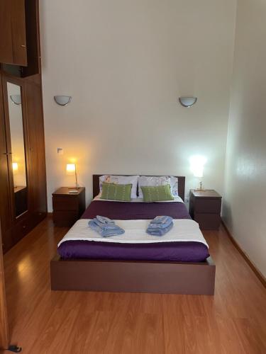 a bedroom with a large bed with two night stands at Refúgio Das Ondas in Praia da Vitória