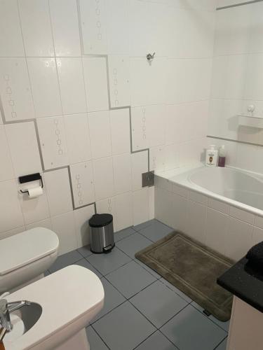 a bathroom with a toilet and a sink and a tub at Refúgio Das Ondas in Praia da Vitória