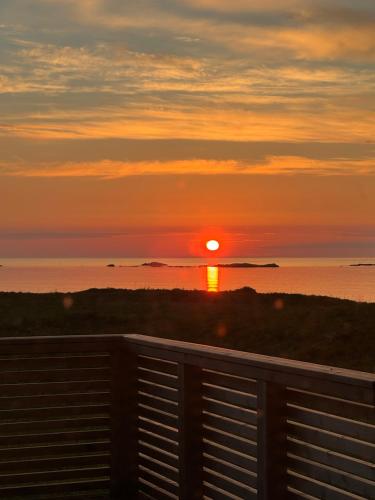 a sunset over the ocean with the sun setting at Oceanfront Infinity Lodge, Lofoten in Vestvågøya