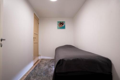 a bedroom with a bed in a white room at Villa floor with patio in Södertälje