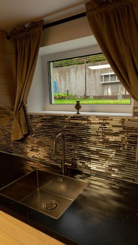 a kitchen with a sink and a window at Villa floor with patio in Södertälje