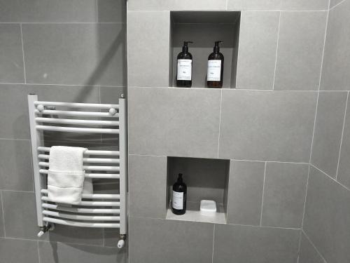 Zwei Flaschen Wein stehen auf einem Regal im Badezimmer. in der Unterkunft LEVEL Terrazas premium con parrillas privadas in Bahía Blanca