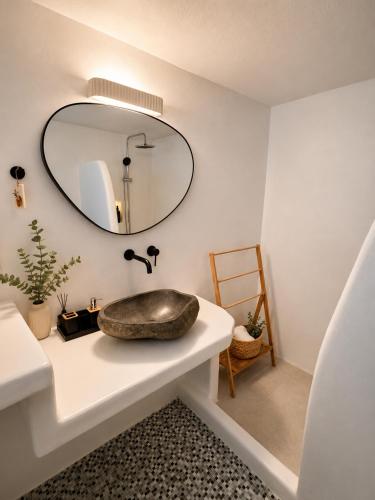 une salle de bains avec un lavabo et un miroir dans l'établissement Maya Mallis, à Adamas
