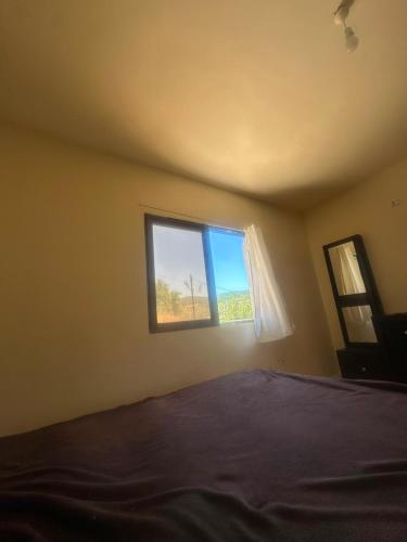 a bedroom with a bed and a window at مطل محنا الجبلي in Ajloun