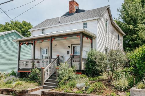 a white house with a porch with a staircase at The Mariposa in Staunton