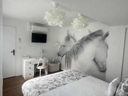 a bedroom with a painting of a horse on the wall at Chez Patou in Laval