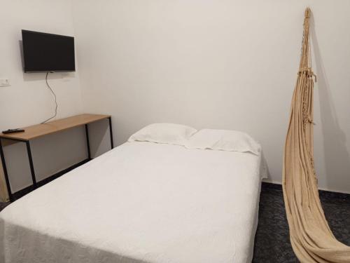 a bedroom with a bed and a tv and a hammock at Apartamento Vó Maria in Triunfo