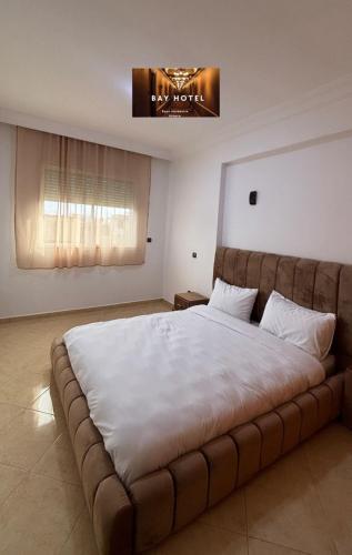 a bedroom with a large bed with a large white blanket at Baya Residentie in Temara