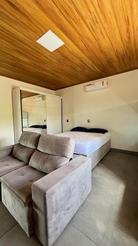 a bedroom with a bed and a couch in it at Casa de Chame Refúgio da Serra in Brasília