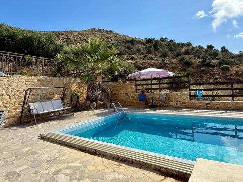 a swimming pool in front of a building with a mountain at Sun Thavma Living studio psiloritis in Lístaros