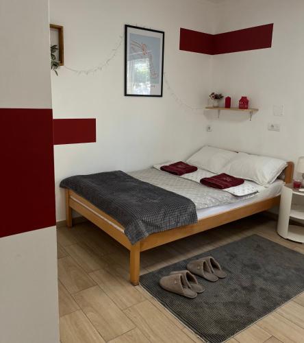 a bedroom with a bed with shoes on it at 'MONAS' mini apartments in Sombor