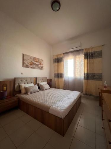 a bedroom with a large bed and a window at Casa Tolentino in Bissau