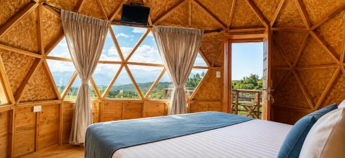 a bedroom with a large window in a yurt at Hotel Finca Buenos Aires Barichara in Barichara