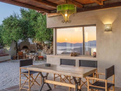 a wooden table and chairs on a patio with a window at Villa Maestoso in Mirsíni