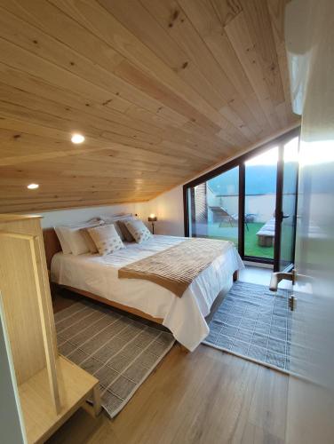 a large bed in a room with a large window at Puro Wild in Geres