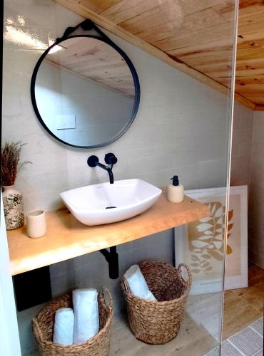 a bathroom with a sink and a mirror and baskets at Puro Wild in Geres