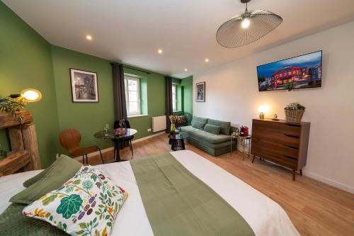 a bedroom with green walls and a bed and a couch at Le Nid d'HAG in Haguenau