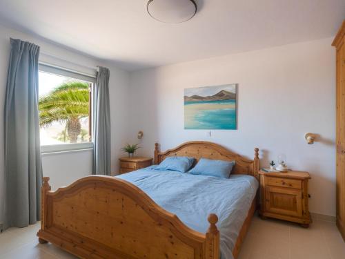 a bedroom with a wooden bed and a window at Casa Zapato in La Pared