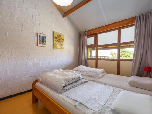 a bedroom with two beds and a window at Duinengolf - Zeeanemoon 10 in Westende