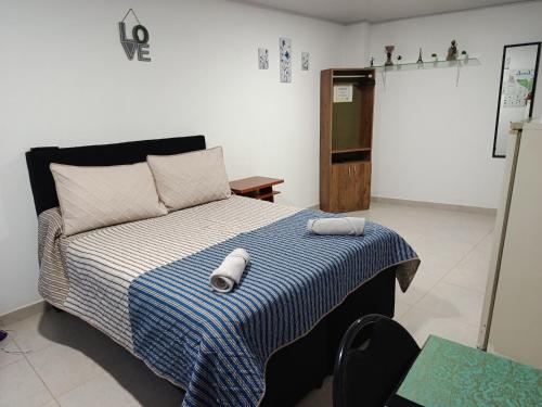 a bedroom with a bed with a blue and white blanket at Mi Rincón Feliz in Choachí
